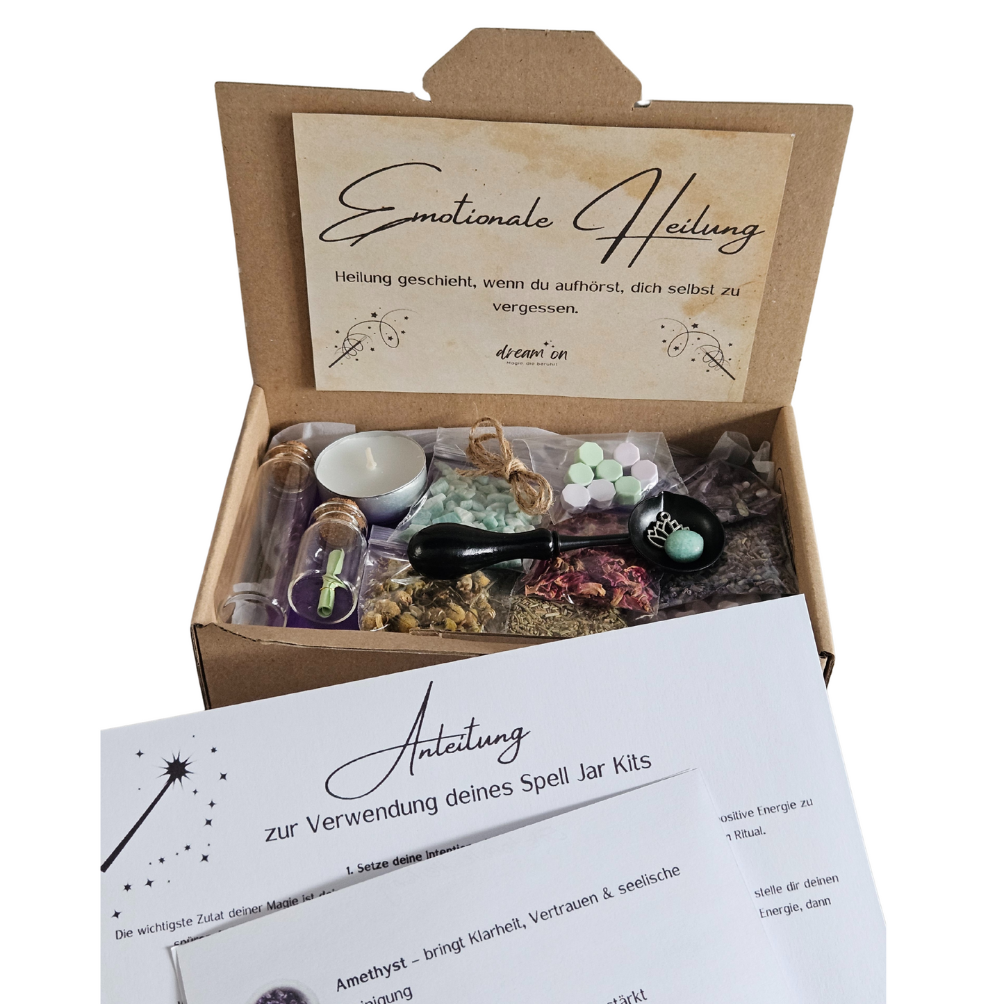 Geöffnete Geschenkbox des DIY-Kreativsets Seelenfrieden von DreamOn, gefüllt mit Naturmaterialien und Zubehör. Im Vordergrund liegt eine gedruckte Anleitung zur Verwendung des Sets mit Beschreibungen zu Amethyst, Rosenquarz und Amazonit.