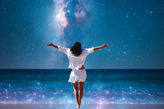 Frau mit offenen Armen am nächtlichen Meer unter einem Sternenhimmel – Symbol für Rückkehr zu sich selbst, Vertrauen und inneres Leuchten.