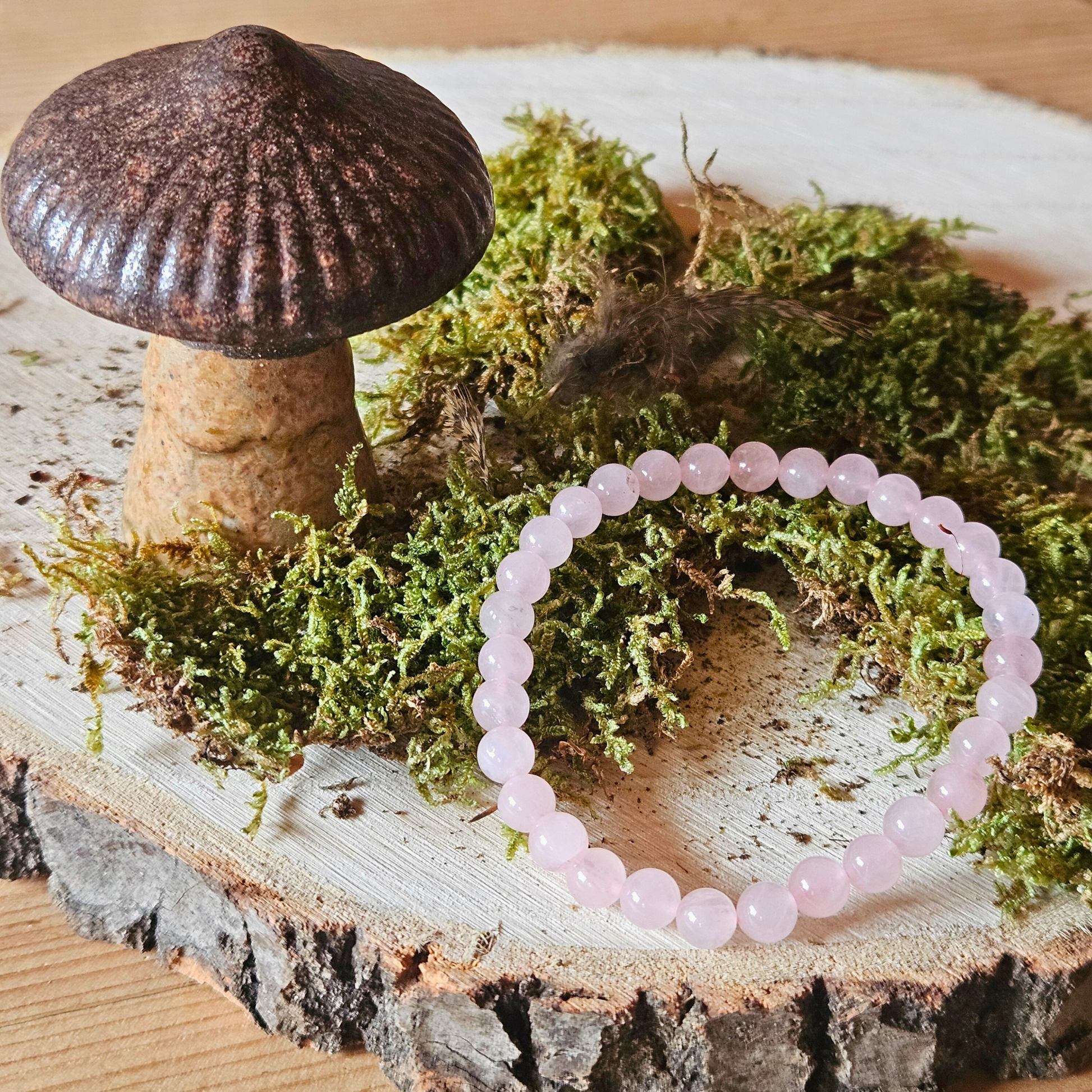 Edelstein Armband Rosenquarz auf grünem Moos im Wald – spirituelles Schmuckfoto mit Naturenergie, DreamOn.
