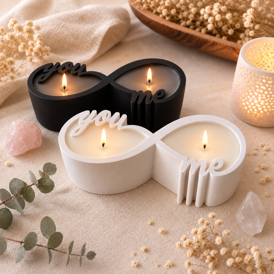 Ästhetische Produktfotografie der brennenden schwarzen und weissen Infinity-Kerzen auf einem beigen Leinentuch, umgeben von Trockenblumen und Heilsteinen.