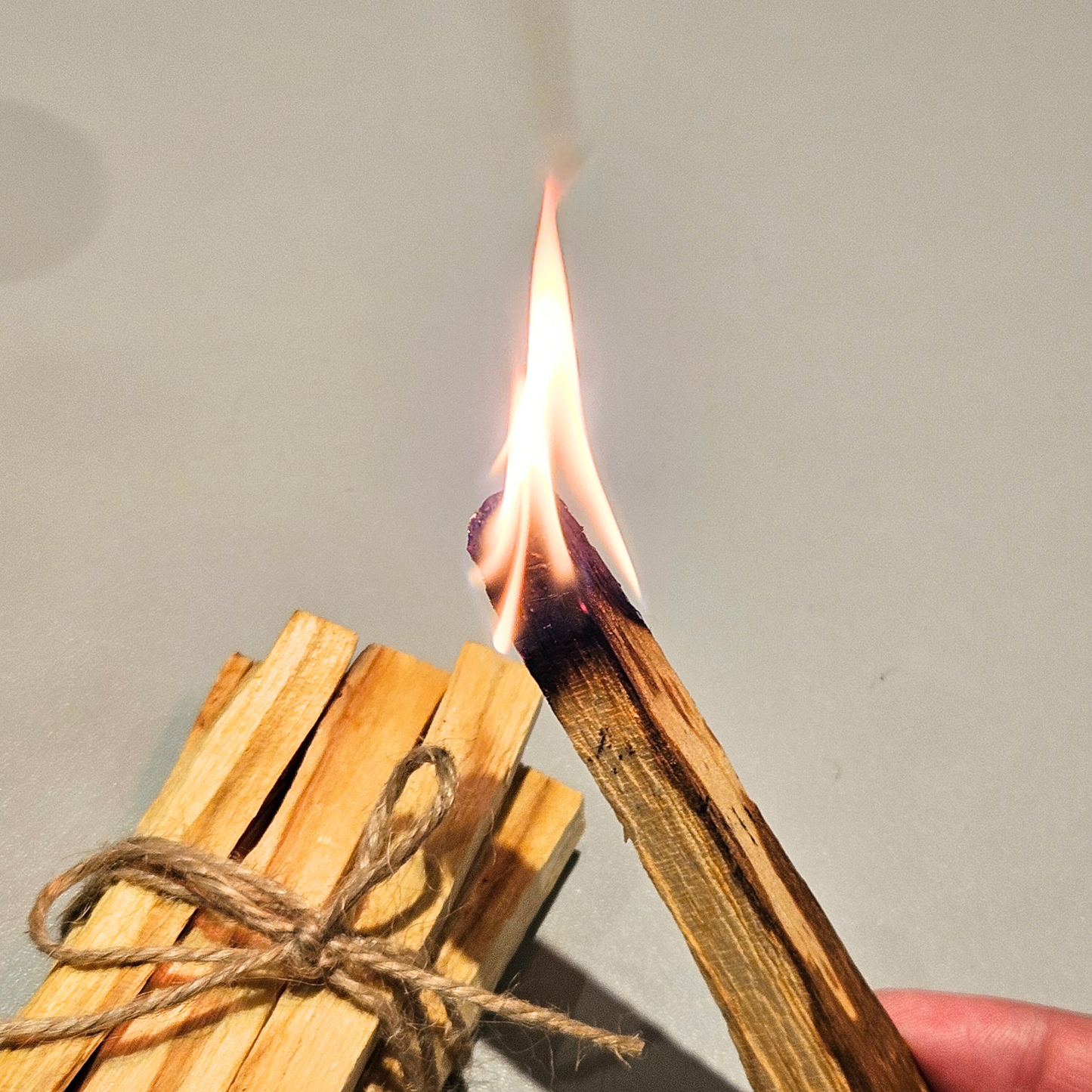 Brennendes Palo Santo Holz beim Räucherritual zur energetischen Reinigung und Klärung