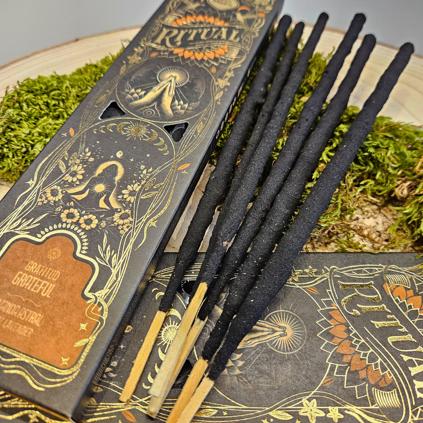 Nahaufnahme der Sagrada Madre Ritualräucherstäbchen Gratitude – Astral Lavender, dekorativ auf Naturmaterialien präsentiert.