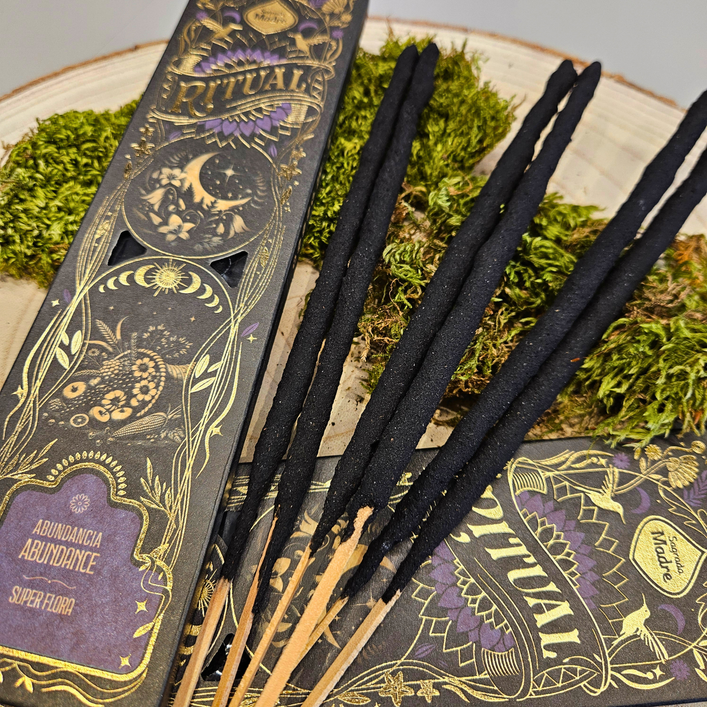 Nahaufnahme der Sagrada Madre Ritualräucherstäbchen Abundance – Super Flora, dekorativ auf Naturmaterialien präsentiert.