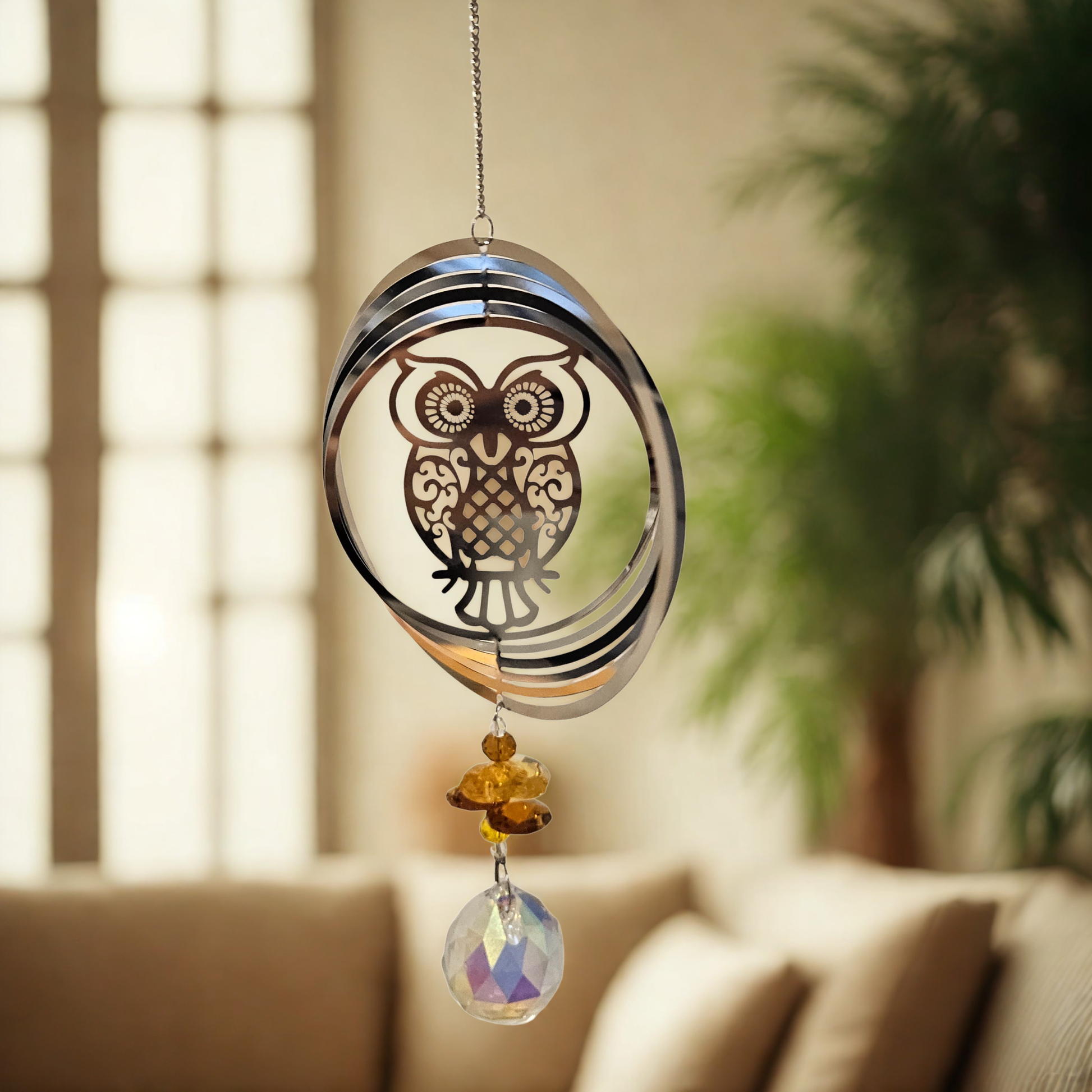 Metall-Suncatcher Windspiel mit Eule und goldenen Kristallen, hängend im Wohnraum.