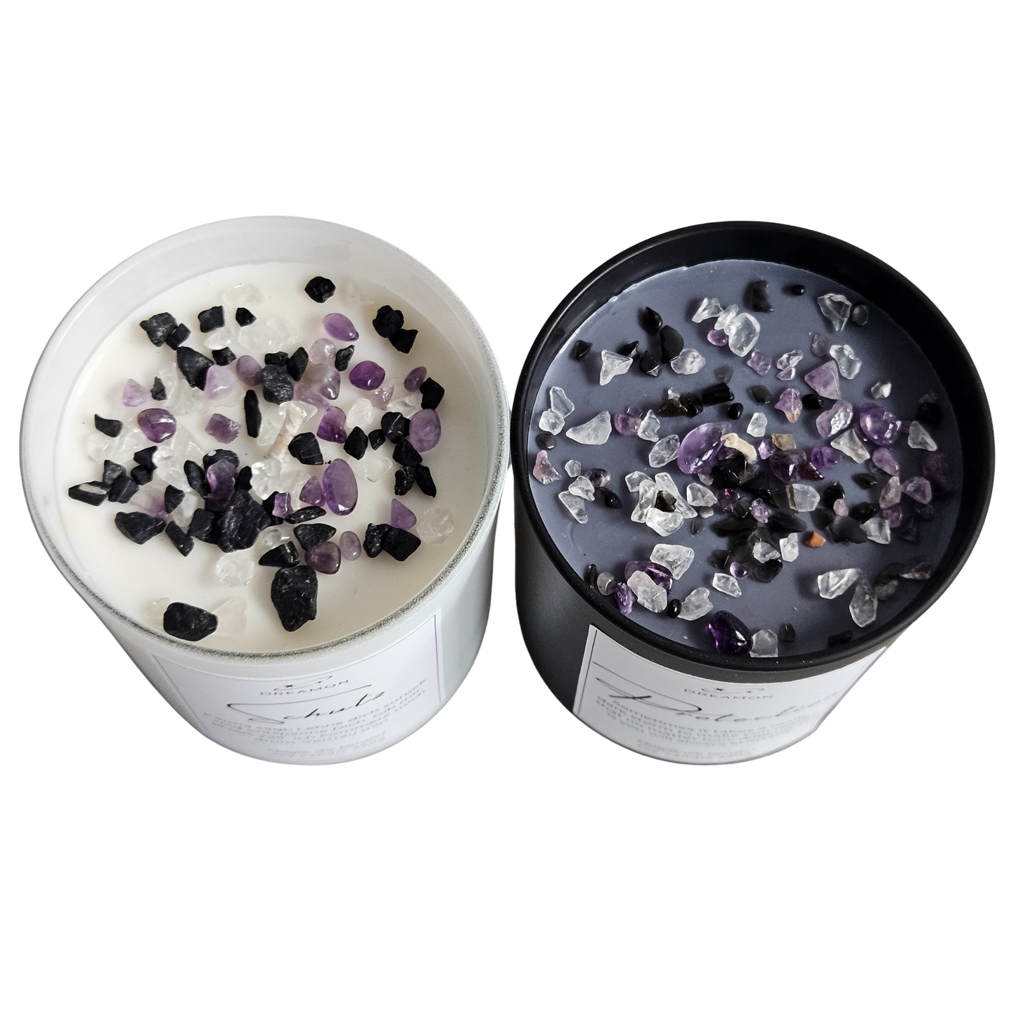 Draufsicht auf zwei handgegossene Duftkerzen im weissen und schwarzen Glas mit freiem Blick auf das Pflanzenwachs, veredelt mit echten Edelsteinen: schwarzer Turmalin, violetter Amethyst und weisser Quarz.
