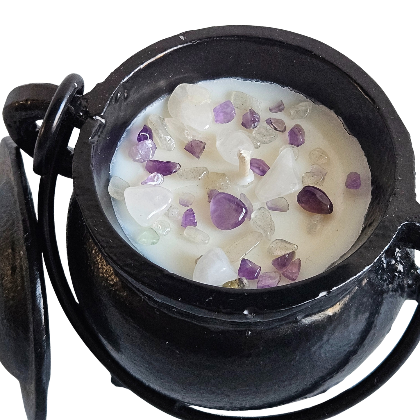 Nahaufnahme von oben auf eine kleine gusseiserne Duftkerze mit vielen kleinen Edelsteinsplittern aus Amethyst und Selenit.