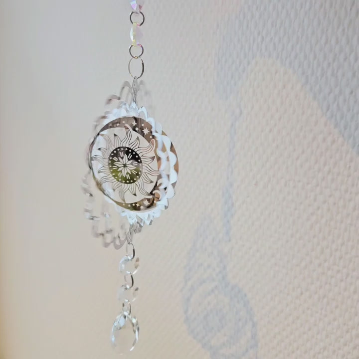 Video von Metall-Suncatcher Windspiel mit Sonne-und-Mond-Design und klaren Kristallen, frontal fotografiert. 